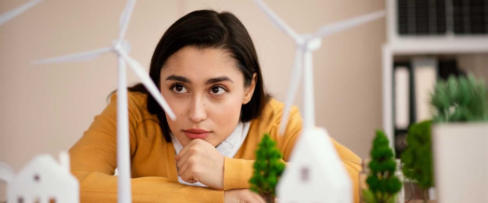 An image of girl sitting and looking at a green landscape carefully to depict “The Hidden Carbon Cost of Real Estate